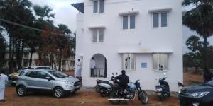a man sitting on a motorcycle in front of a white house at Jamath Villas 1307 in Kīlakarai