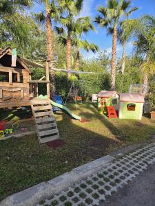 a childrens playground with palm trees and a swing at Casa Moschetti in Capodrise