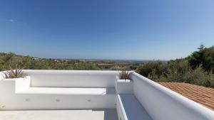 a white balcony with plants on a roof at Tenuta Olive Alive in Noto