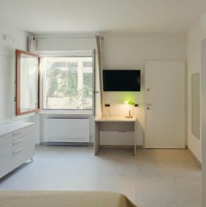 a white room with a desk and a television at Giosalea Tropea in Tropea