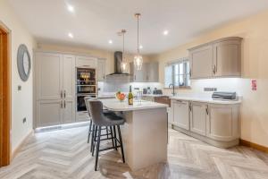 a kitchen with white cabinets and a island with chairs at 3 Bed in Brampton oc-p34636 in Brampton