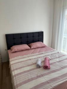 a bed with two pillows and two towels on it at Eos in Çeşme +13 photos