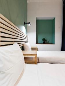 two beds in a room with a green screen at Cosyroom 3 in Pieta