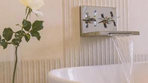 a bathroom with a sink and a vase with a flower at Tenuta Olive Alive in Noto