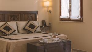 a bedroom with a bed and a table with a cup on it at Tenuta Olive Alive in Noto