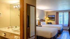a hotel room with two beds and a mirror at Cahilty #313 home in Sun Peaks