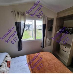 a bedroom with a bed with purple writing on the wall at Snowdon Summit 017 in Barmouth