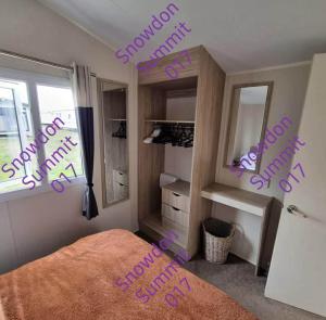 a bedroom with a bed with purple writing on the wall at Snowdon Summit 017 in Barmouth