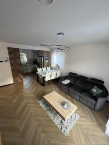 a living room with a black couch and a table at Opole Calm House in Opole