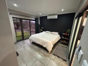 a bedroom with a bed and a large window at House 110 in Hoedspruit