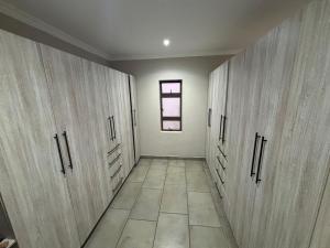 a hallway with wooden cabinets and a window at House 110 in Hoedspruit +9 photos