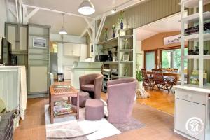 a kitchen with pink chairs and a dining room at Au blavet douillet in Lochrist