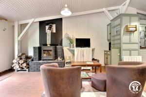 a living room with a stove and some chairs at Au blavet douillet in Lochrist