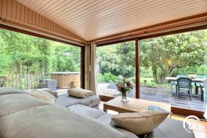 a living room with a couch and a large window at Au blavet douillet in Lochrist