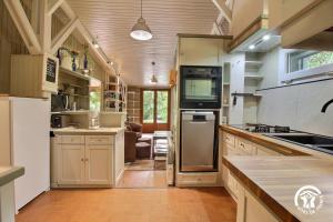 a large kitchen with a stove and a refrigerator at Au blavet douillet in Lochrist +29 photos