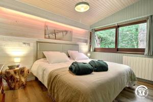 a bedroom with a bed with two green pillows on it at Au blavet douillet in Lochrist