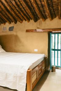 a bedroom with a bed in a room with a window at Posada Los Tres Arrieros in Jordán