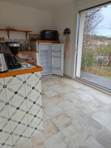 a kitchen with a tile floor and a window at Le Rocher au Thym in Limoux