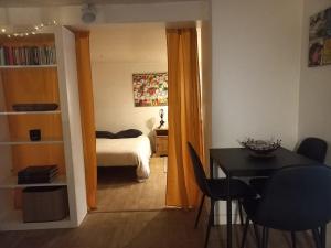 a room with a table and a bedroom with a bed at Le Nid in Avignon