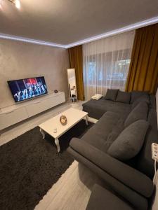 a living room with a couch and a tv at holiday apart in Oradea