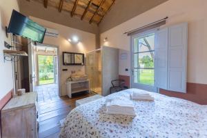 a bedroom with a bed and a tv on the wall at B&B Il Molinello in Asciano