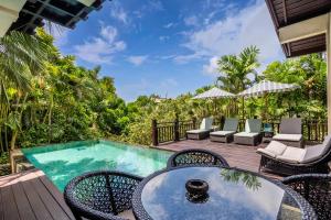 a patio with a table and chairs and a swimming pool at Boutique hotel villa Cantik and karma beach club in Uluwatu +85 photos