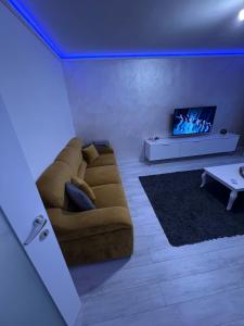 a living room with a couch and a tv at holiday apart in Oradea +5 photos