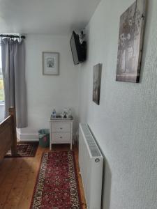 a room with a heater and a white wall at Sharlands Farm Bed and Breakfast in Bude