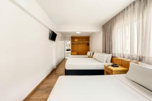 a hotel room with two beds and a window at Slim Hotel São Paulo Congonhas in São Paulo +89 photos