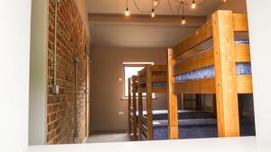 a room with bunk beds and a brick wall at 3 Peaks Bunkroom in Settle +15 photos