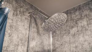 a shower with a shower head in a bathroom at 3 Peaks Bunkroom in Settle