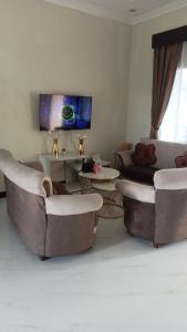a living room with couches and a flat screen tv at Kulla villa dieng in Wonosobo