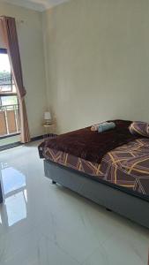 a bedroom with a bed and a large window at Kulla villa dieng in Wonosobo