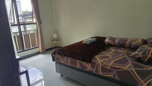 a bedroom with a bed and a large window at Kulla villa dieng in Wonosobo +5 photos