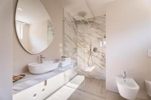a white bathroom with a sink and a mirror at Hotel Diana in Malcesine +123 photos