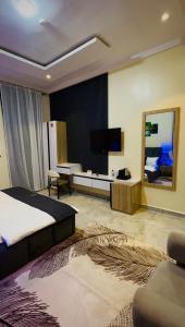 a bedroom with a bed and a television in a room at Flora By Bibaley Hotel in Kaduna
