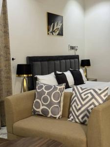 a bed with pillows on a couch in a room at Flora By Bibaley Hotel in Kaduna