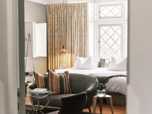 a bedroom with a bed and a couch and a window at Atemporal by Andean in Lima