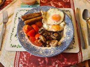 a blue and white plate of food with an egg and vegetables at High Standard Double-room near Gatwick Airport in Horley