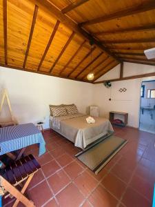 a bedroom with a bed and a wooden ceiling at Pousada chalés São Geraldo in Lima Duarte