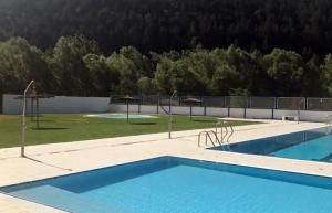 two swimming pools with trees in the background at Apartament Tritó - Rústico y acogedor con vistas - 2p in Guardiola de Berguedà