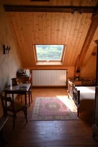 a bedroom with a bed and a table and a window at Le Deyran in Égliseneuve-dʼEntraigues