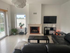 a living room with a couch and a fireplace at Wellnesshouse in Atouguia da Baleia