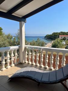 a chair on a balcony with a view of the ocean at Apartmani Hranjec in Ugljan