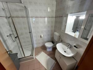 a bathroom with a shower and a sink and a toilet at Apartmani Hranjec in Ugljan