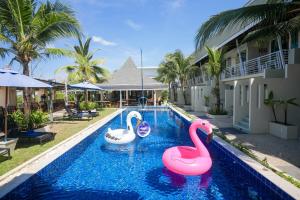 two inflatable flamingos in a swimming pool at a resort at Impress Resort, Phuket - Free scheduled shuttle from Hotel to Phuket Airport in Thalang