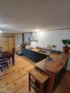 a large kitchen and dining room with a wooden floor at Apparemment spacieux in Massat +22 photos