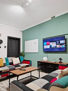a living room with couches and a flat screen tv at Cosy room 2 in Pieta +15 photos