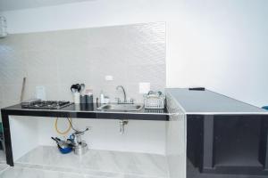 a kitchen with a sink and a stove at Apartamentos King Arthur in Punta Seca