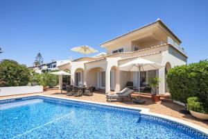a villa with a swimming pool and a house at Casa Juniper in Praia do Carvoeiro